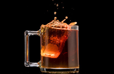 making black tea from a bag with sugar in motion on a black background
