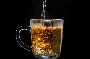 making black tea from a bag with sugar in motion on a black background