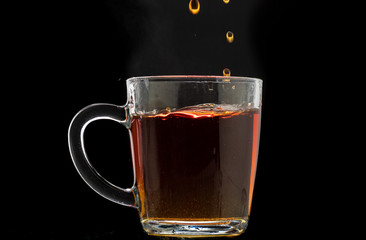 making black tea from a bag with sugar in motion on a black background