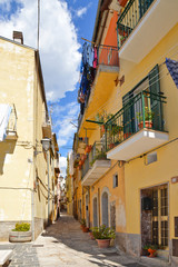 A narrow street between squares, monuments and colorful buildings in the town of Isernia, in Italy