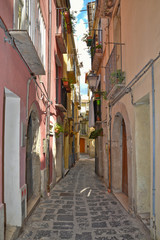 Fototapeta na wymiar A narrow street between squares, monuments and colorful buildings in the town of Isernia, in Italy