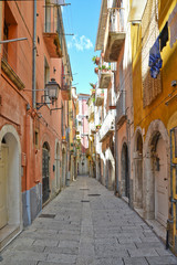 Fototapeta na wymiar A narrow street between squares, monuments and colorful buildings in the town of Isernia, in Italy