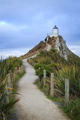 Fototapeta na wymiar Nugget Point lighthouse on overcast stormy day South Island New Zealand