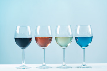 Wine Varieties. Four Glasses of Wine on Table – Red Wine, Rose, White and Blue Wine