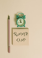 Text sign showing Summer Camp. Business photo text Supervised program for kids and teenagers during summertime. Metal vintage alarm clock wakeup blank notepad marker colored background