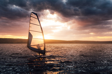 Windsurfing on a lake at sunset.