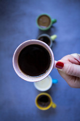 Coffee cup in woman hand, close up, top view.