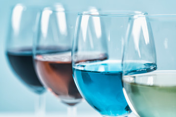 Wine Varieties. Four Glasses of Wine on Table – Red Wine, Rose, White and Blue Wine