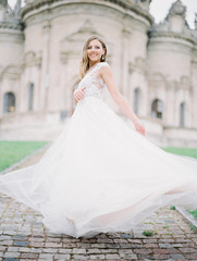 Stylish and beautiful bride portrait near the old Church. Film analog photography