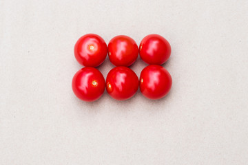 Red cherry tomatoes on a kraft paper background. Small tomatoes.