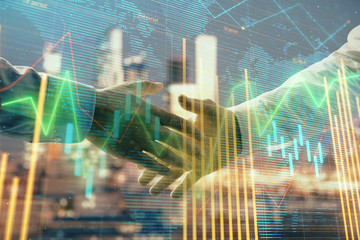 Double exposure of financial chart and world map on cityscape background with two businessmen handshake. Concept of international investment