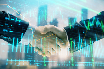 Double exposure of financial graph on cityscape background with two businessman handshake. Concept of stock market deal