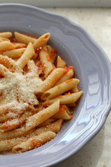 Plate of pasta with homemade tomato sauce. and grated parmesan cheese on top. Selective focus.