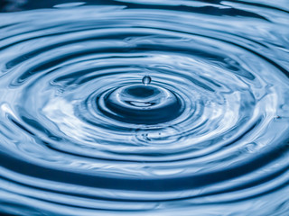 Naklejka na ściany i meble water drop splash in a glass blue colored