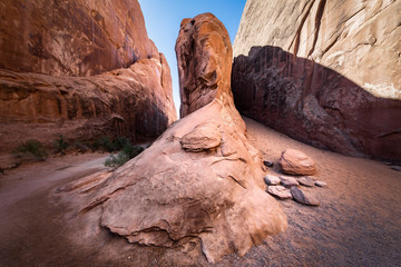 Wide angle view of a red sandstone monolith in the middle of a canyon