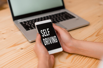 Handwriting text Self Driving. Conceptual photo Autonomous vehicle Ability to navigate without huanalysis input woman laptop computer smartphone mug office supplies technological devices