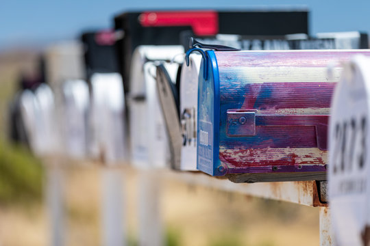 Close up of a long row of mismatched and weathered traditional american letterboxes