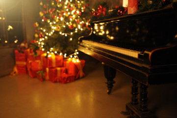 Evening christmas with christas tree and many gift box near piano