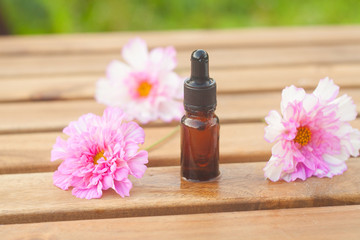 Essence of  flowers on table in beautiful glass Bottle