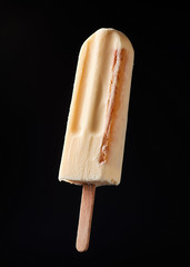Fruit ice-cream on a stick on a black background