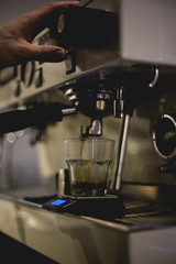 barista pouring milk in glass on table
