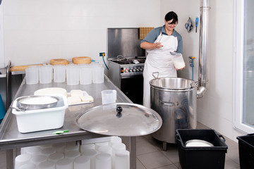Cheesemaker pours the rennet