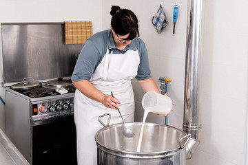 Cheesemaker pours the rennet