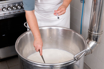 Cheesemaker pours the rennet with a syringe