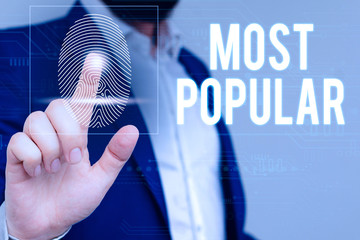 Writing note showing Most Popular. Business concept for Liked Followed Enjoyed by majority of the showing in a society Male wear formal work suit presenting presentation smart device