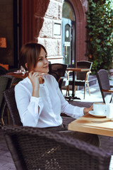 A beautiful girl sits in a cafe and dreams.