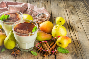 Autumn healthy drinks and snacks. Pear smoothie with cocoa chocolate and spices - cinnamon, anise, with mint leaves. On a rustic wooden background, copy space