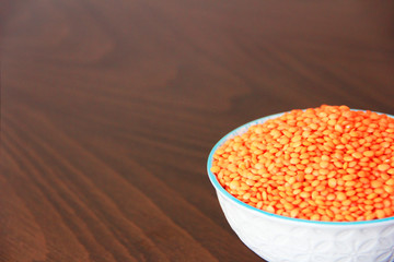 orange natural dried small lentils in a white ceramic plate