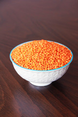 orange natural dried small lentils in a white ceramic plate