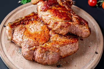 Grilled beef steaks with spices on wooden cutting board