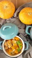 Pumpkin roast in a blue pan on a wooden table