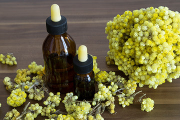 Fototapeta premium The Helichrysum Arenarium golden grass on the wooden background.