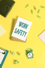 Text sign showing Work Safety. Business photo showcasing Policies and control in place according to government standard Pile of empty papers with copy space on the table