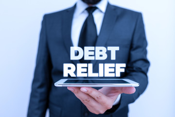 Writing note showing Debt Relief. Business concept for partial or total remission of it especially...
