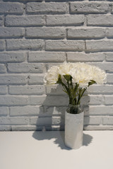 The flowers in the pastic bottle which wrapped eith the white paper for decoration.