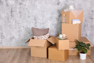 Bunch of blank unsigned moving boxes in new empty apartment. Spacious unfurnished room with...