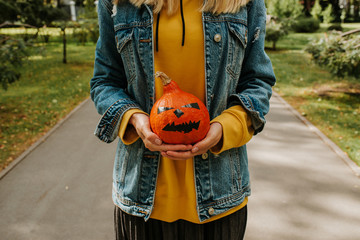 Halloween pumpkin. Woman holding a scary face pumpkin. Happy Halloween party holiday. Celebrate...