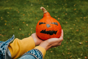 Halloween pumpkin. Woman holding a scary face pumpkin. Happy Halloween party holiday. Celebrate...