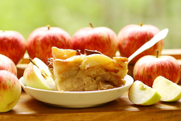 pieces of fresh baked apple pie among raw apples country style still life