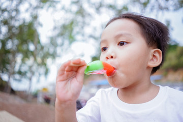 little asian kid eating popsicle ice cream 