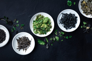 Various dry seaweed, sea vegetables, shot from the top on a black background with a place for text - obrazy, fototapety, plakaty
