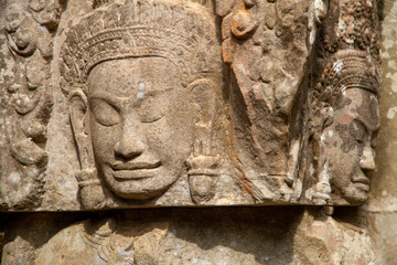 Fototapeta na wymiar Closeup of faces carved in relief, Angkor Wat, Cambodia