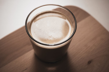 coffee served in a glass on a wooden board background