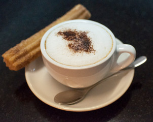Churros con chocolate served in a restaurant.