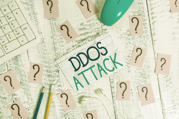 Writing note showing Ddos Attack. Business concept for perpetrator seeks to make network resource unavailable Writing tools and scribbled paper on top of the wooden table