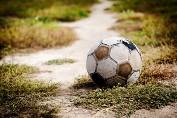 Old soccer ball lying on the grass for street football before the start of the game. Selective focus. © kasia2003